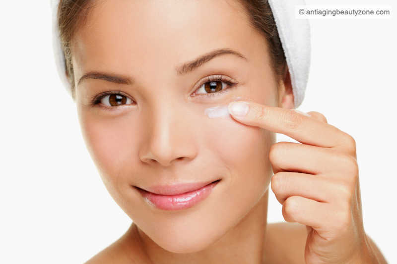 Woman applying under-eye serum to reduce puffiness and wrinkles.