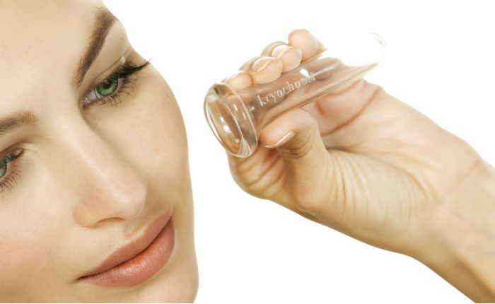 Woman using a silicone facial cupping cup for at-home face lift massage