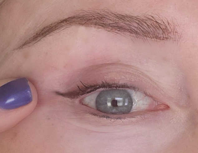 Tiny eyeliner flick on a mature hooded eye after opening the eye to check the angle