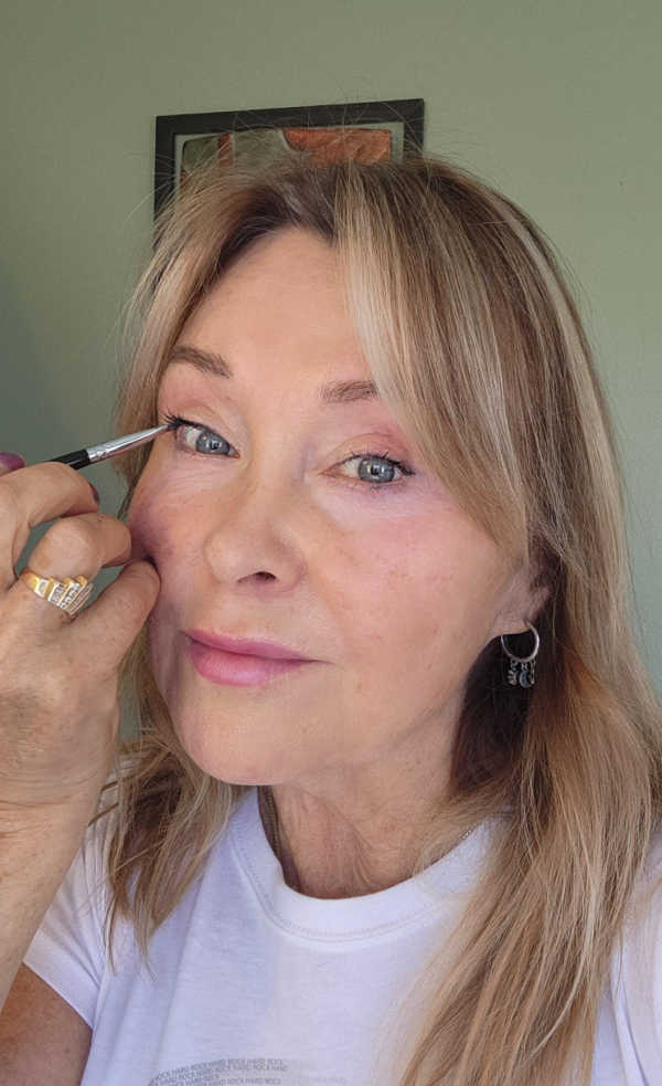 Linda applying hunter green gel eyeliner to the upper outer waterline for a soft, lifted look.