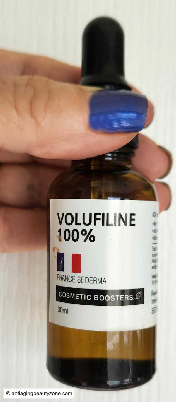 Linda holding a bottle of Volufiline 100% cosmetic booster used in her hand care routine for aging hands