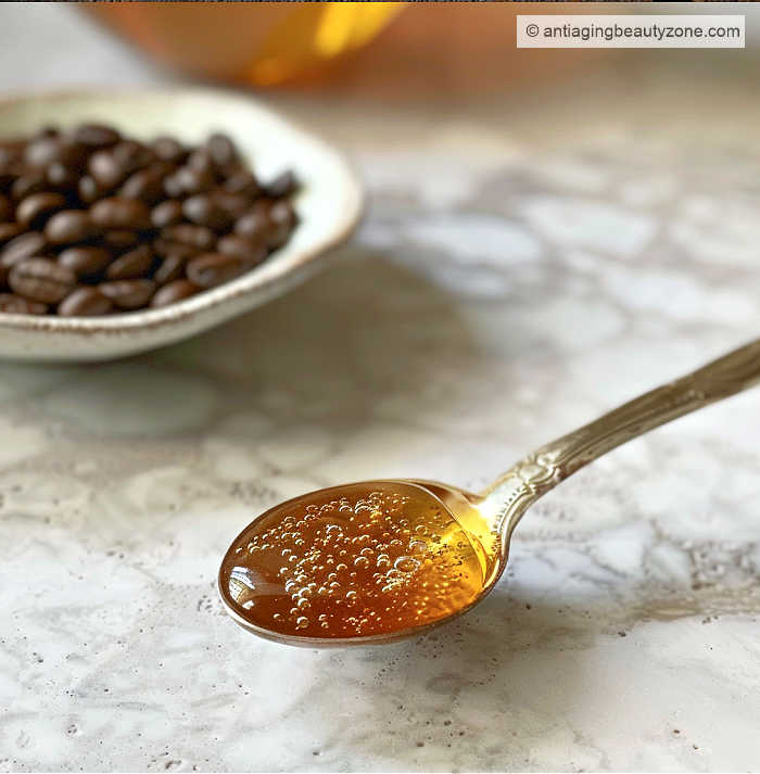 Honey and coffee grounds for puffy eyes. Tablespoon of honey near coffee beans.