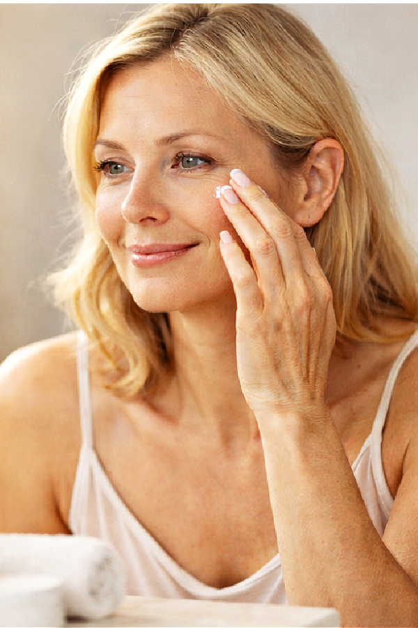Woman gently touching the outer corner of her eye with a calm expression