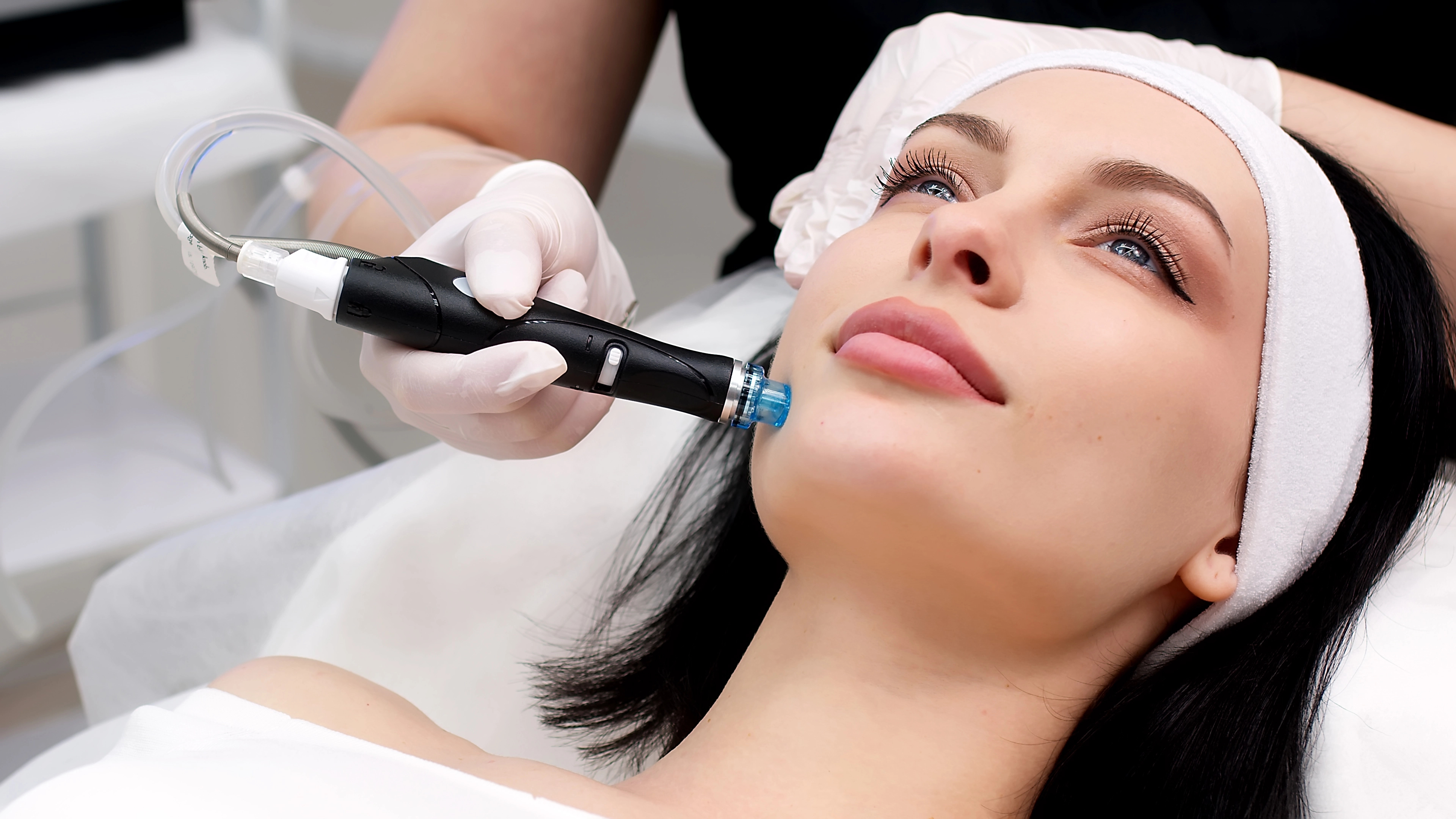 Exploring Skin Treatments: HydraFacial and Diamond Microdermabrasion benefits for skin aging. Woman getting a HydraFacial treatment in a spa for skin rejuvenation.
