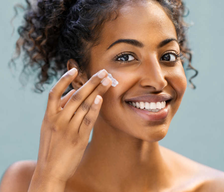 woman applying moisturizer after microdermabrasion