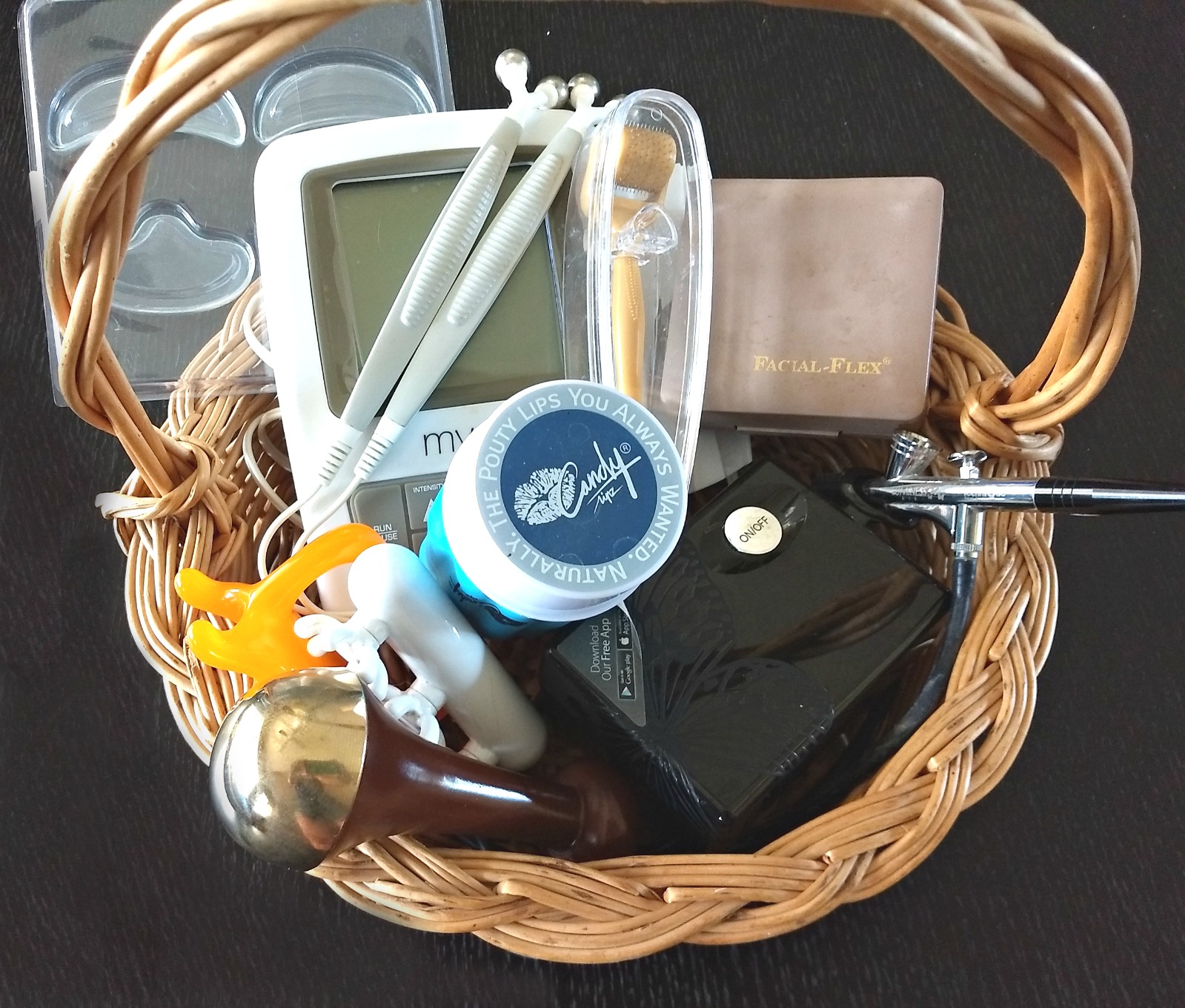 A basket filled with facial exercise tools, massage devices, and beauty gadgets I’ve tested over the years.