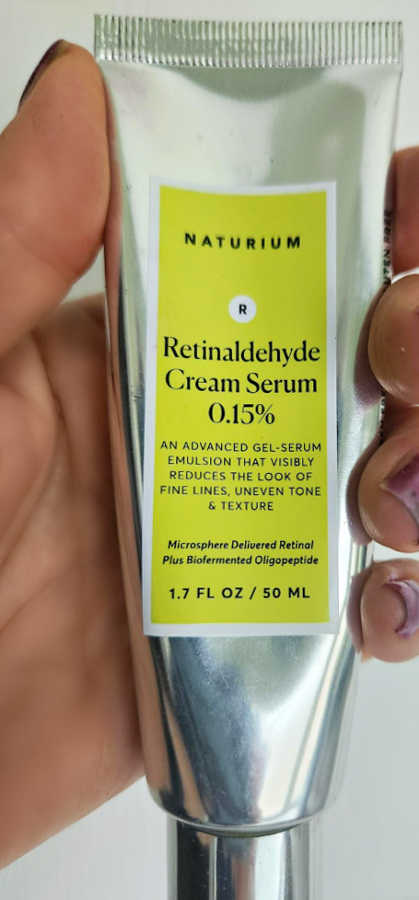My Naturium retinal skincare tube in hand Close-up of a hand holding a Naturium retinaldehyde skincare tube