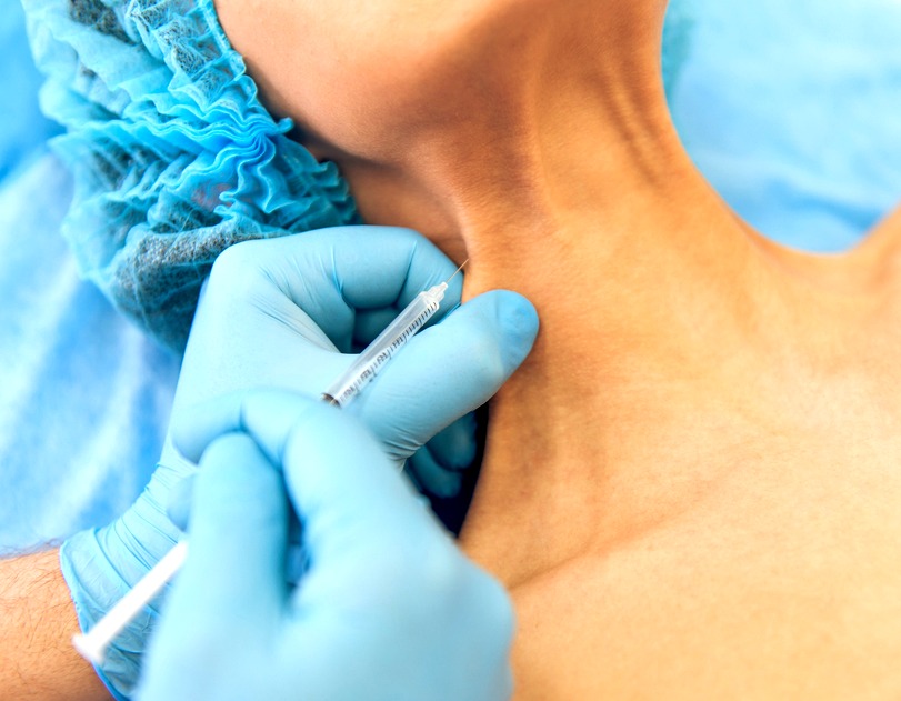 Woman getting Botox in her neck area.