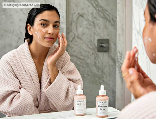 Woman applying niacinamide serum to damp skin for enhanced absorption and brighter complexion