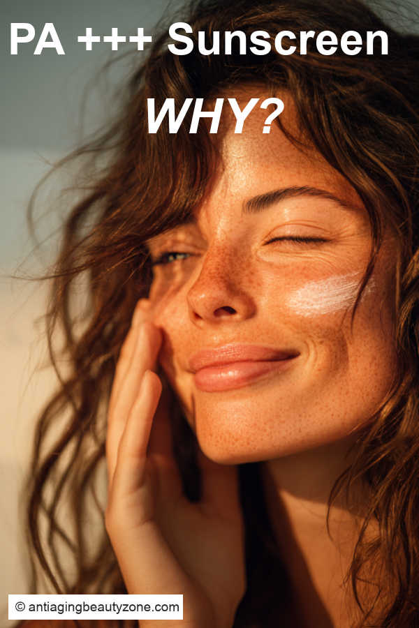 Smiling woman applying PA+++ sunscreen to her cheek in warm sunlight, highlighting daily UVA protection for anti-aging skin care.