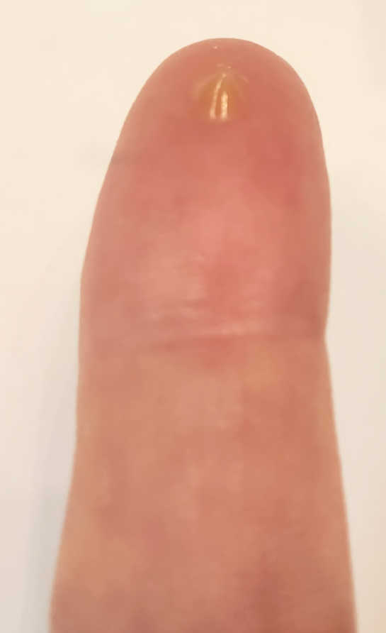Small amount of Peter Thomas Roth Instant FIRMx Eye Tightener on fingertip showing the light flesh-colored serum