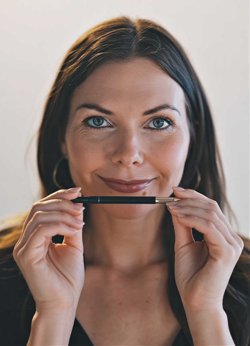 Woman holding eyeliner pencil showing eyeliner tips for aging eyes