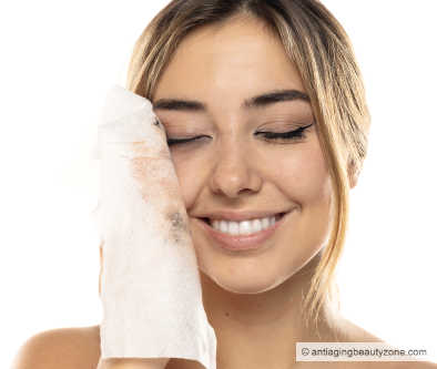 A woman is using natural makeup removal wipes to cleanse her face gently.