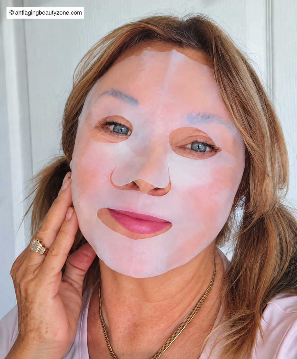 Linda Robison wearing a sheet mask to test how it fits and feels on mature skin
