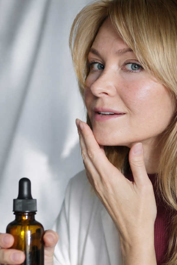 Woman applying face serum as part of a simple skincare routine
