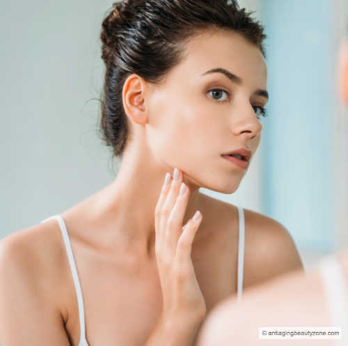 Pros and cons to dermaplaning skin exfoliation treatment. woman looking at her skin after at-home, DIY Dermaplaning.